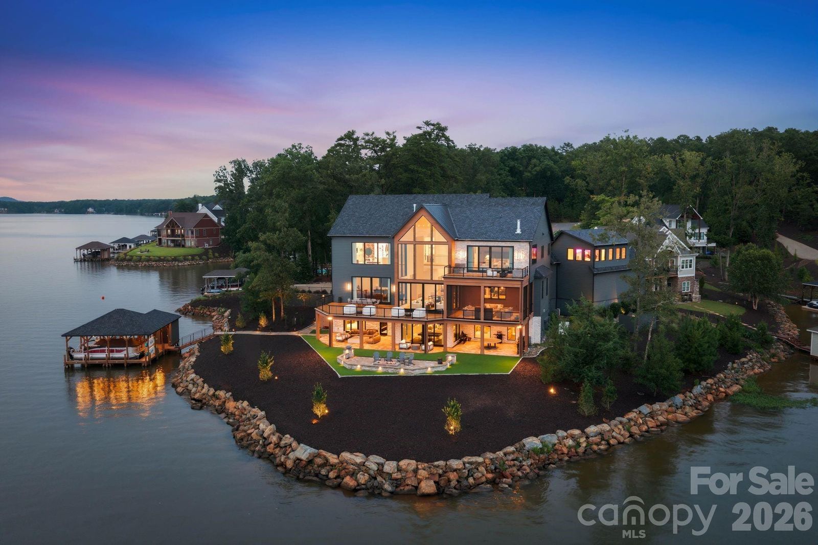 Aerial view of 123 Cove Point on the point of a peninsula on Lake Tillery at dusk, with the boathouse at the shoreline