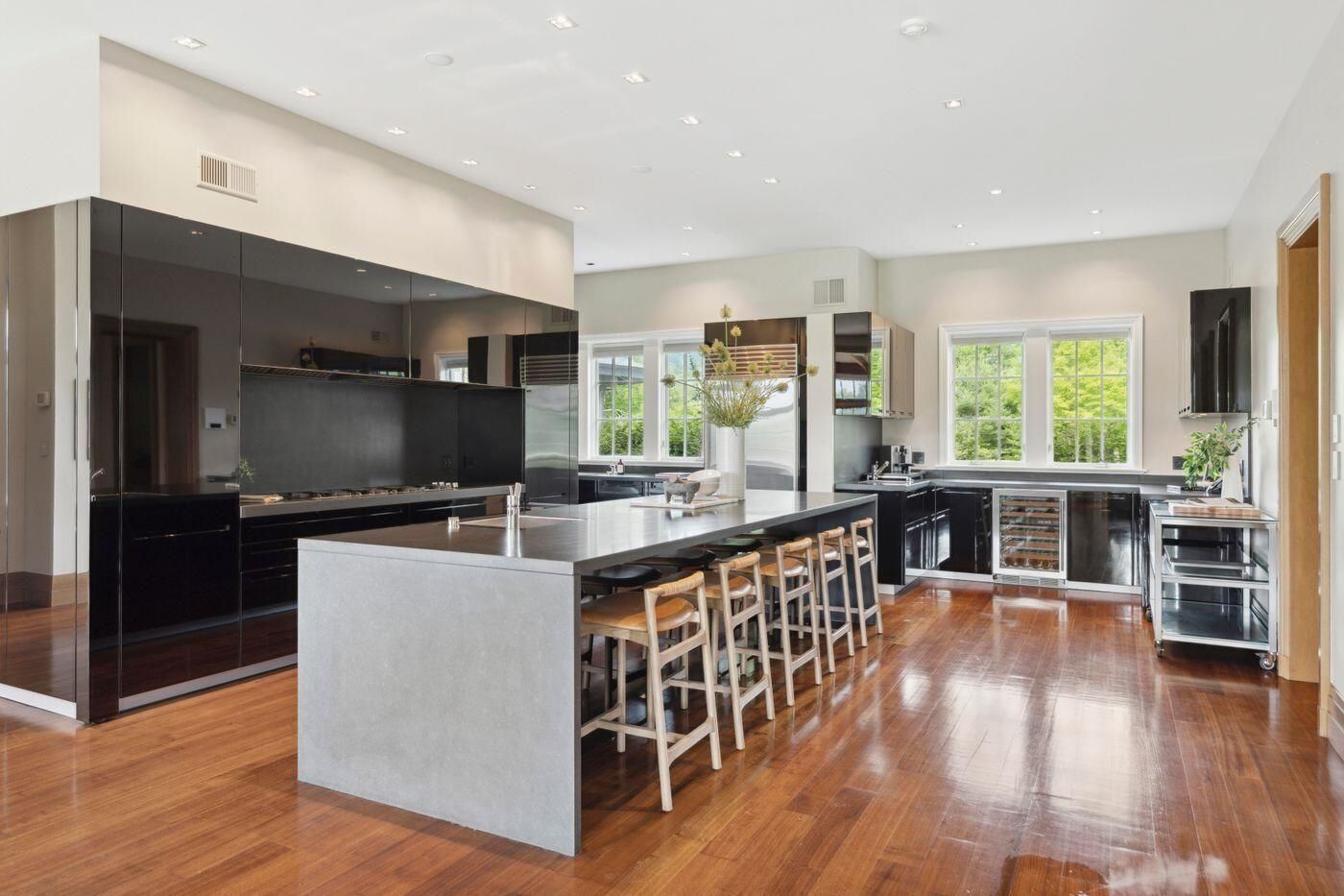 Boffi kitchen with dark cabinetry, large island, and hardwood floors at 2575 Weeks Hill Road, Stowe, Vermont